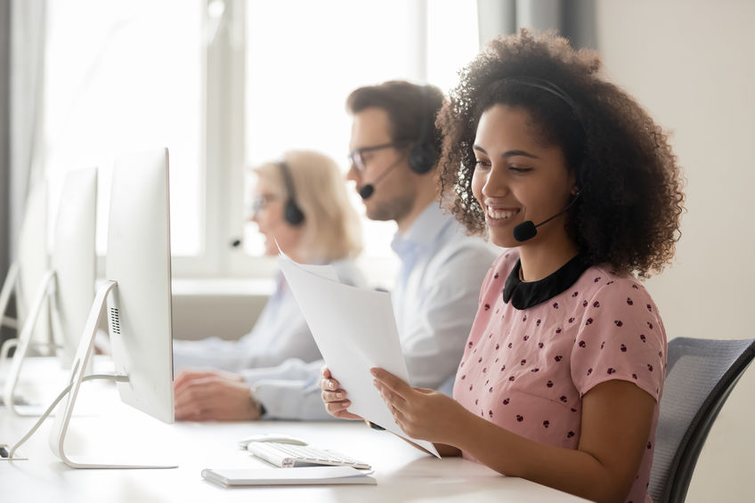 call center employee with headset in front of computer