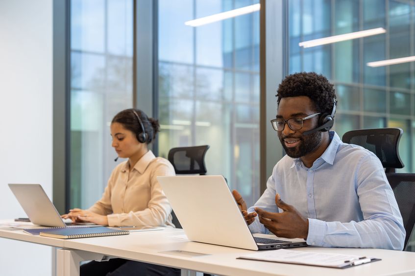customer support team using laptops and headsets in modern office environment. focused on communication, teamwork, assistance. suitable for business, technology, and online service themes.